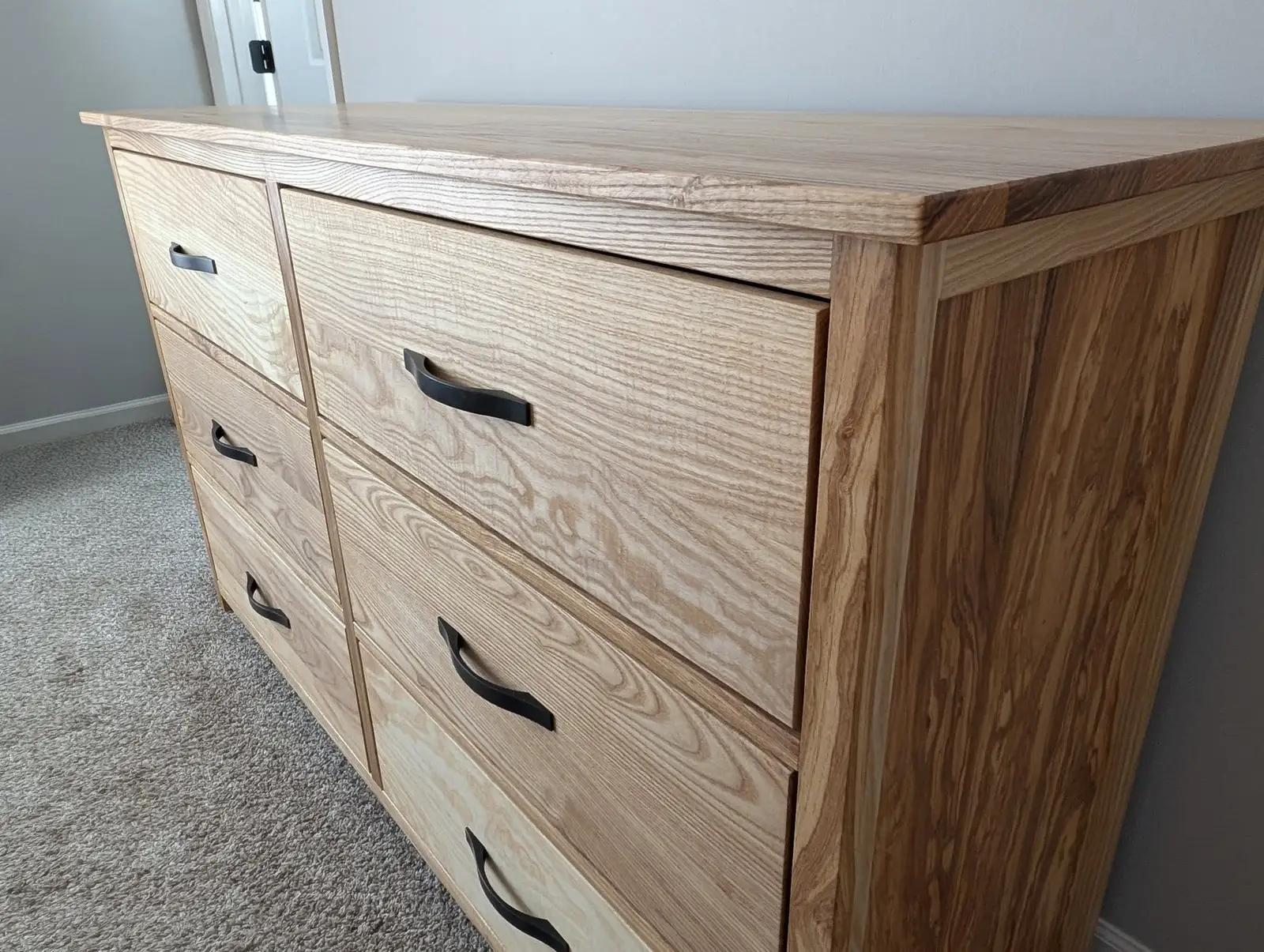 Close-up of figured ash grain across the dresser's drawer fronts
